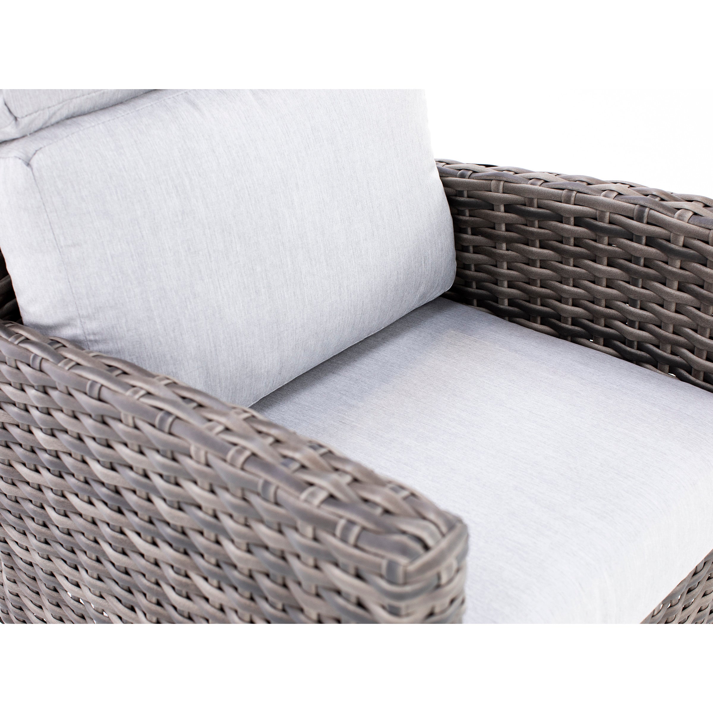 Close-up of a wicker armchair with light gray cushions.