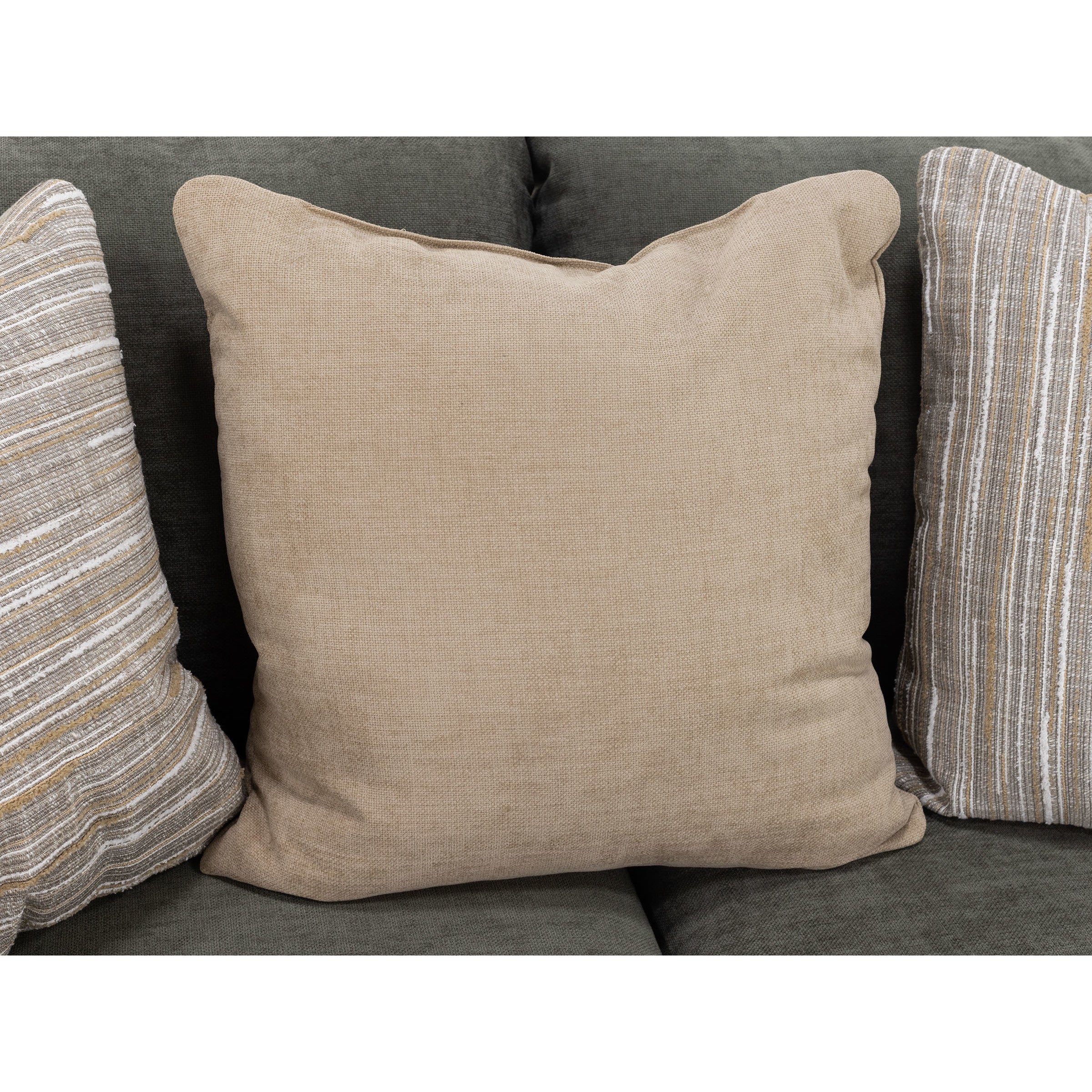 Beige decorative pillow on dark sofa, flanked by striped accent pillows.