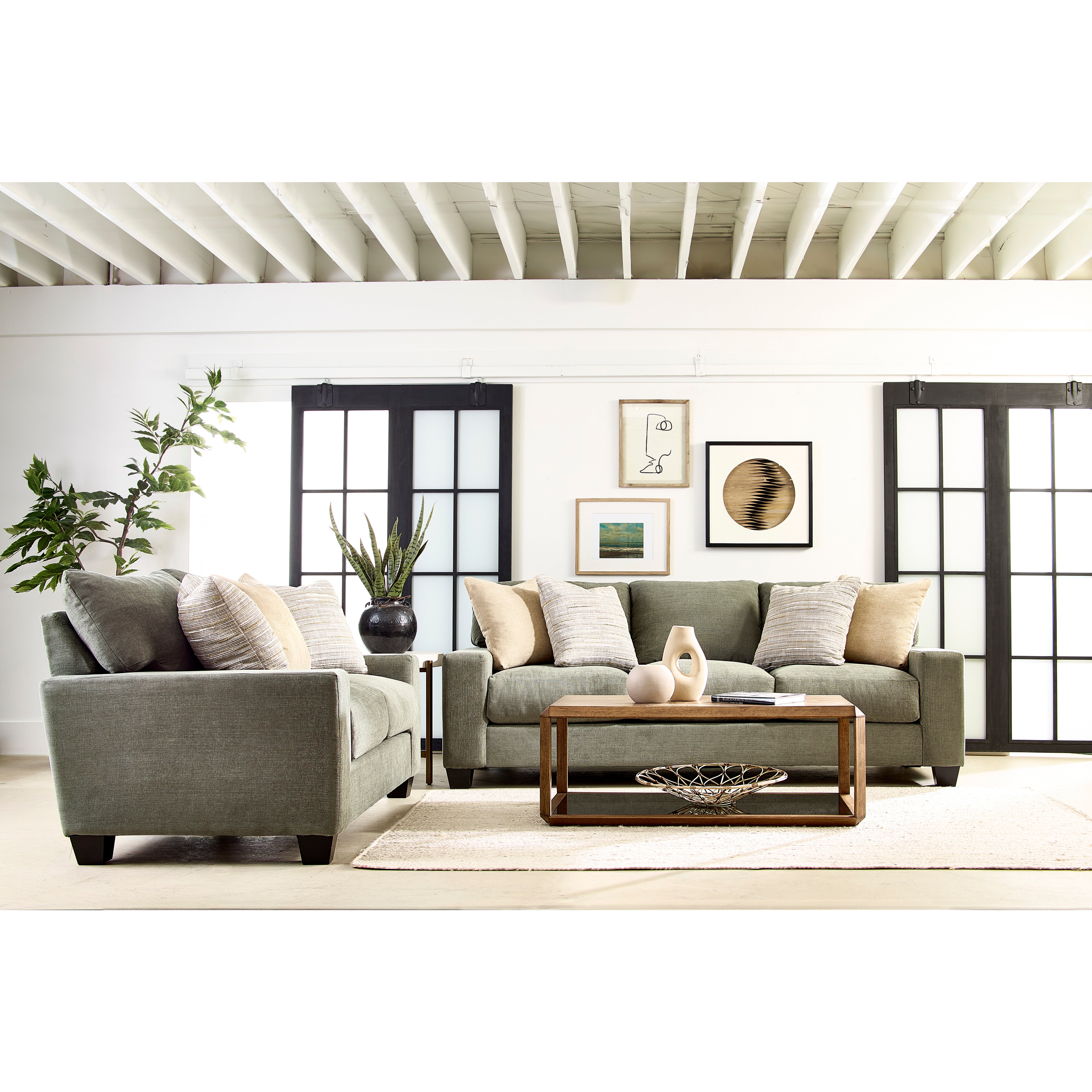 Modern living room with gray sofas, decorative pillows, coffee table, and wall art.