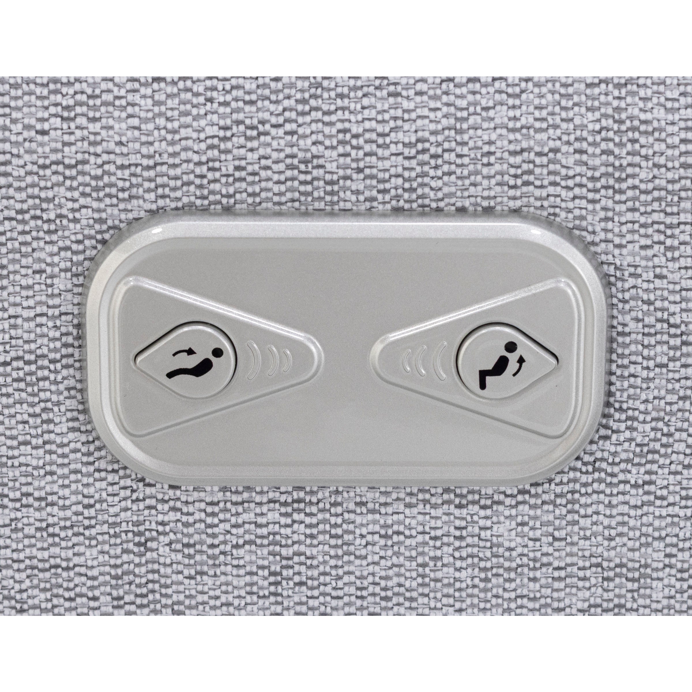 Close-up of two seat adjustment buttons on a textured surface.