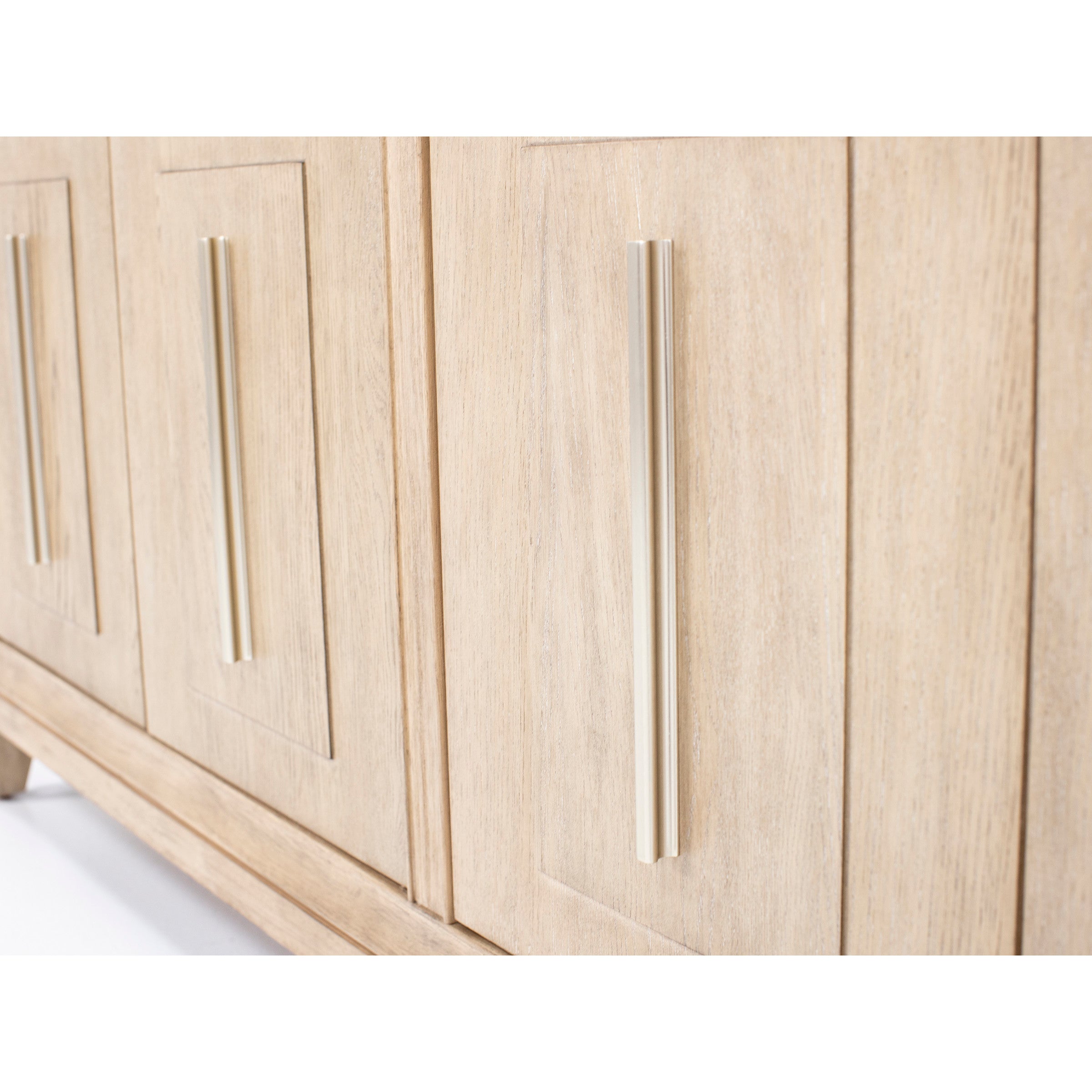 Close-up of a light wood cabinet with modern vertical metal handles.