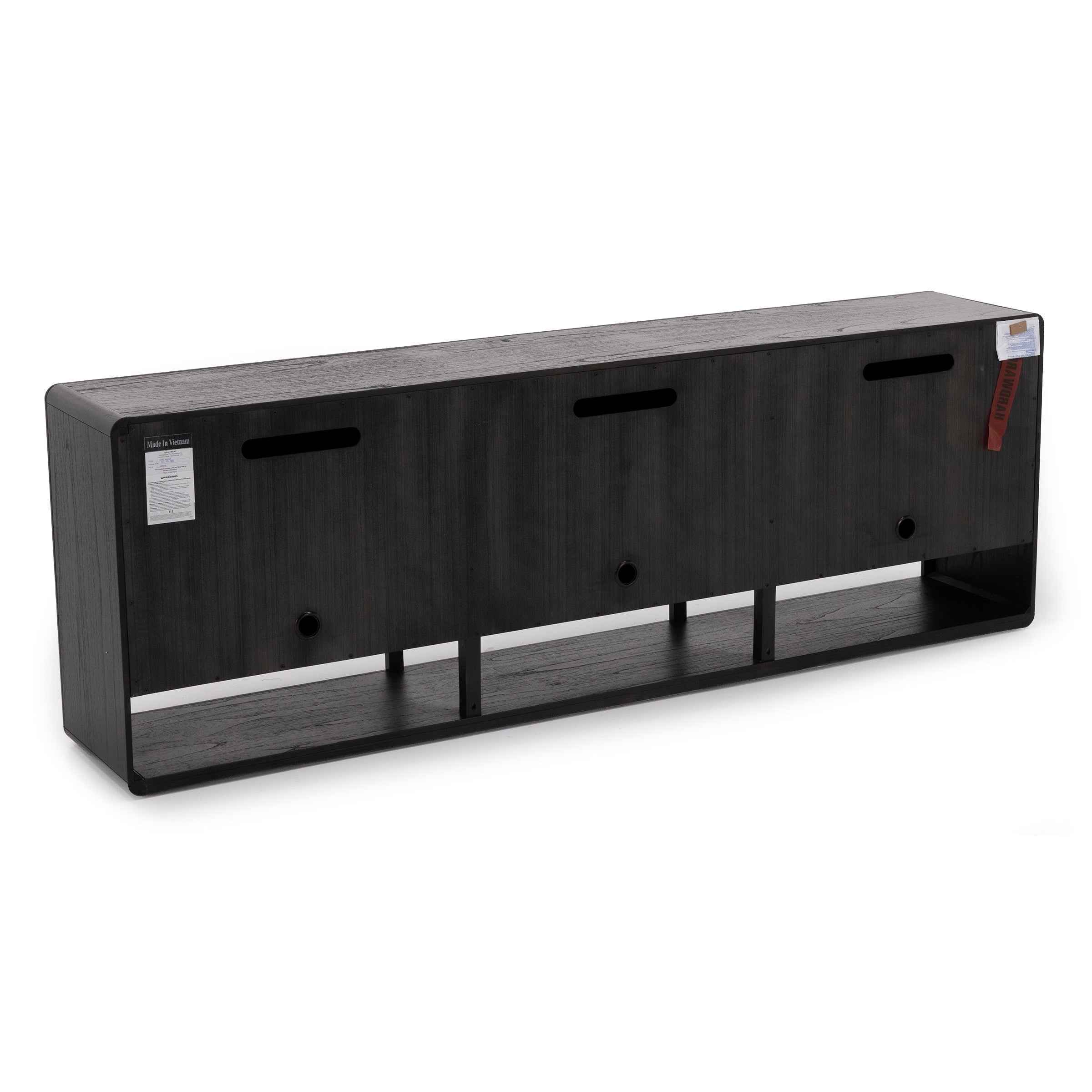 Back view of a long black wood TV stand with ventilation holes and cable cutouts.