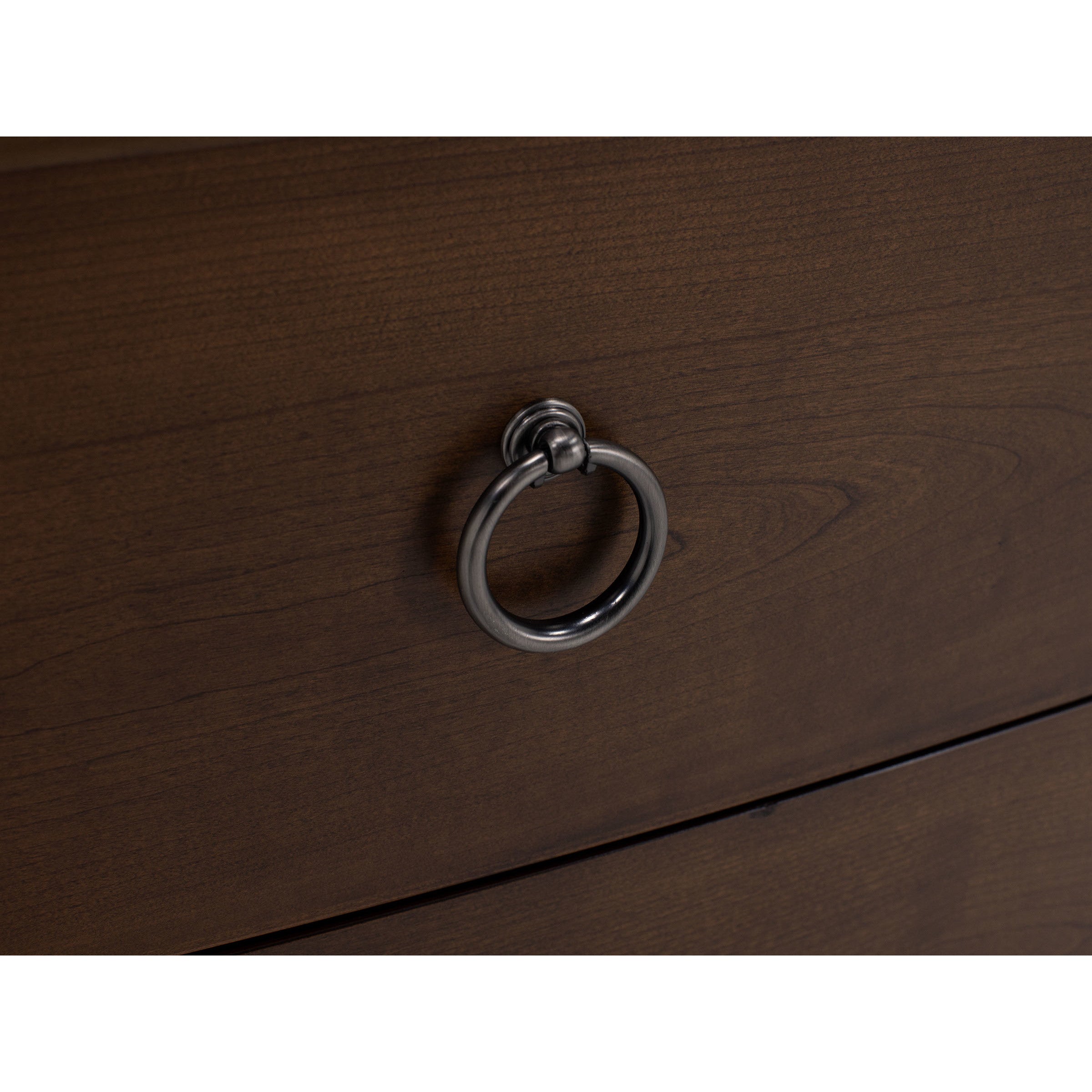 Close-up of a dark wood drawer with a round metal pull handle.
