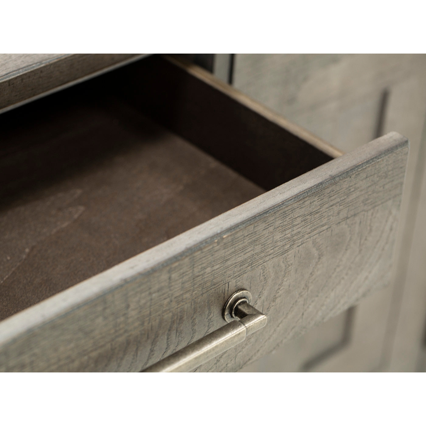 Close-up of an empty, open wooden drawer with a metal handle.