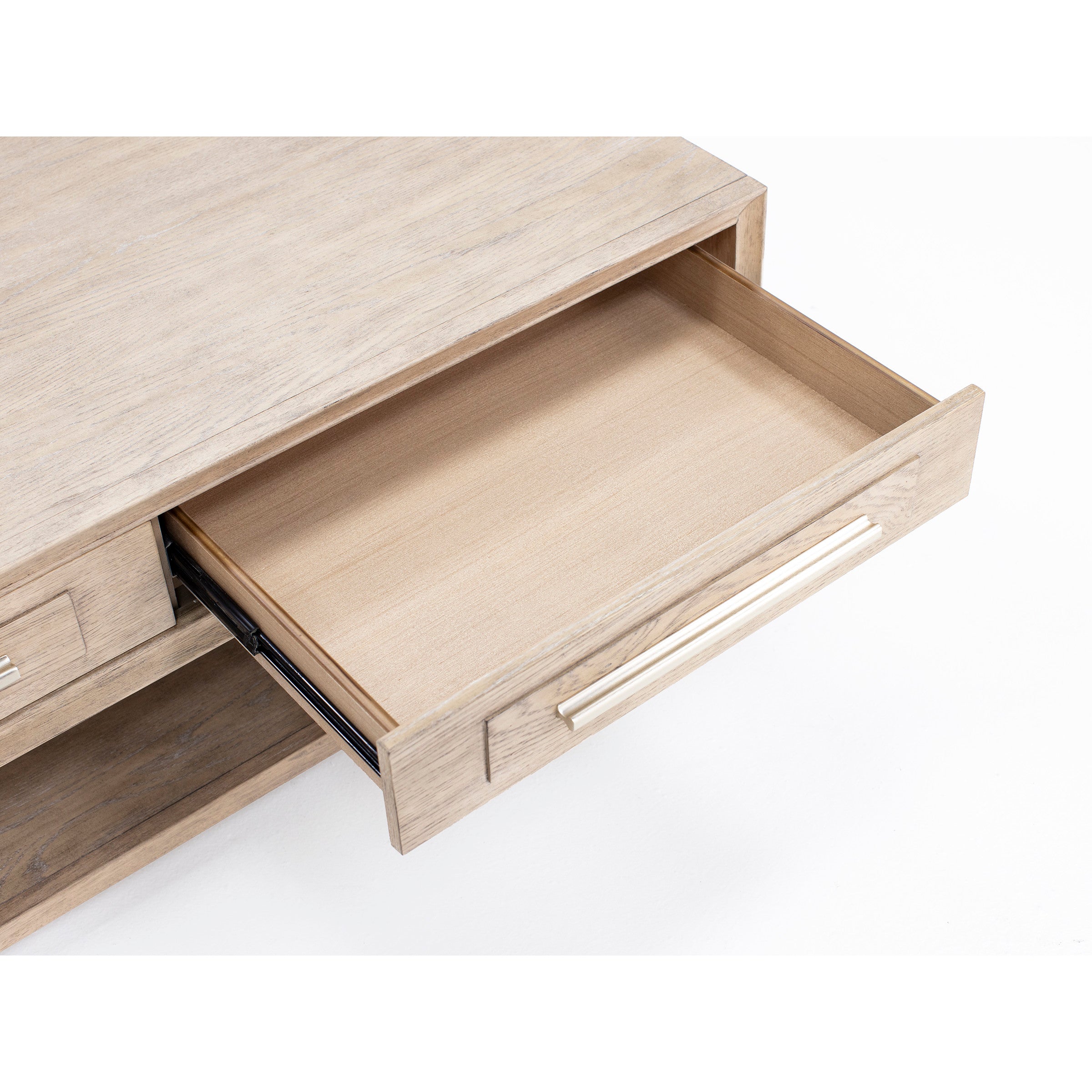 Open drawer in light wood furniture, showing interior space.