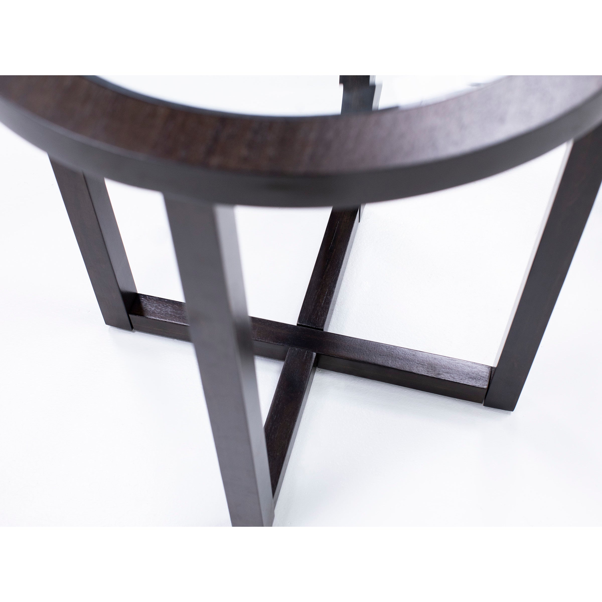 Close-up of dark wood table legs in a crossed design on a white background.