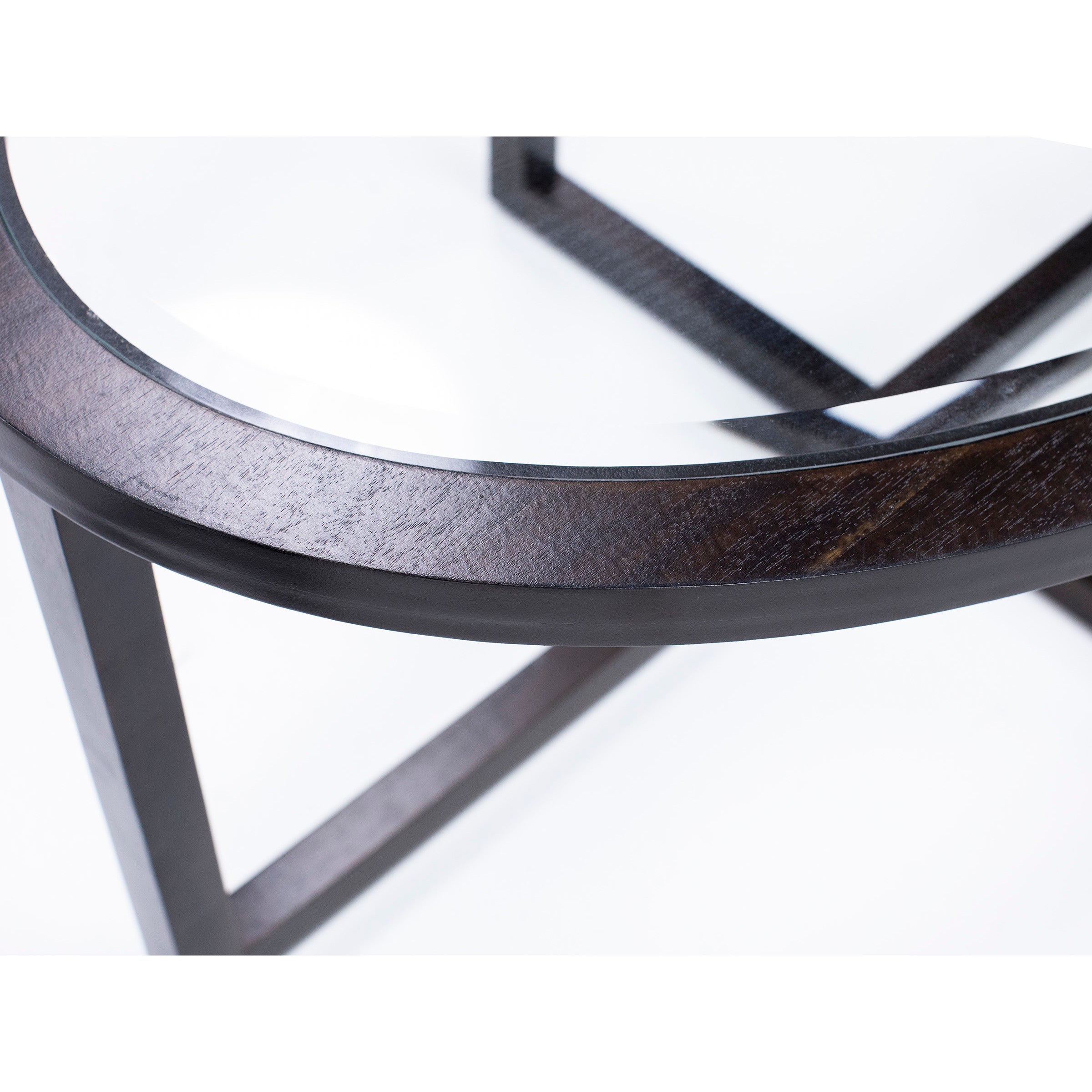 Close-up of a dark wood and glass table edge.