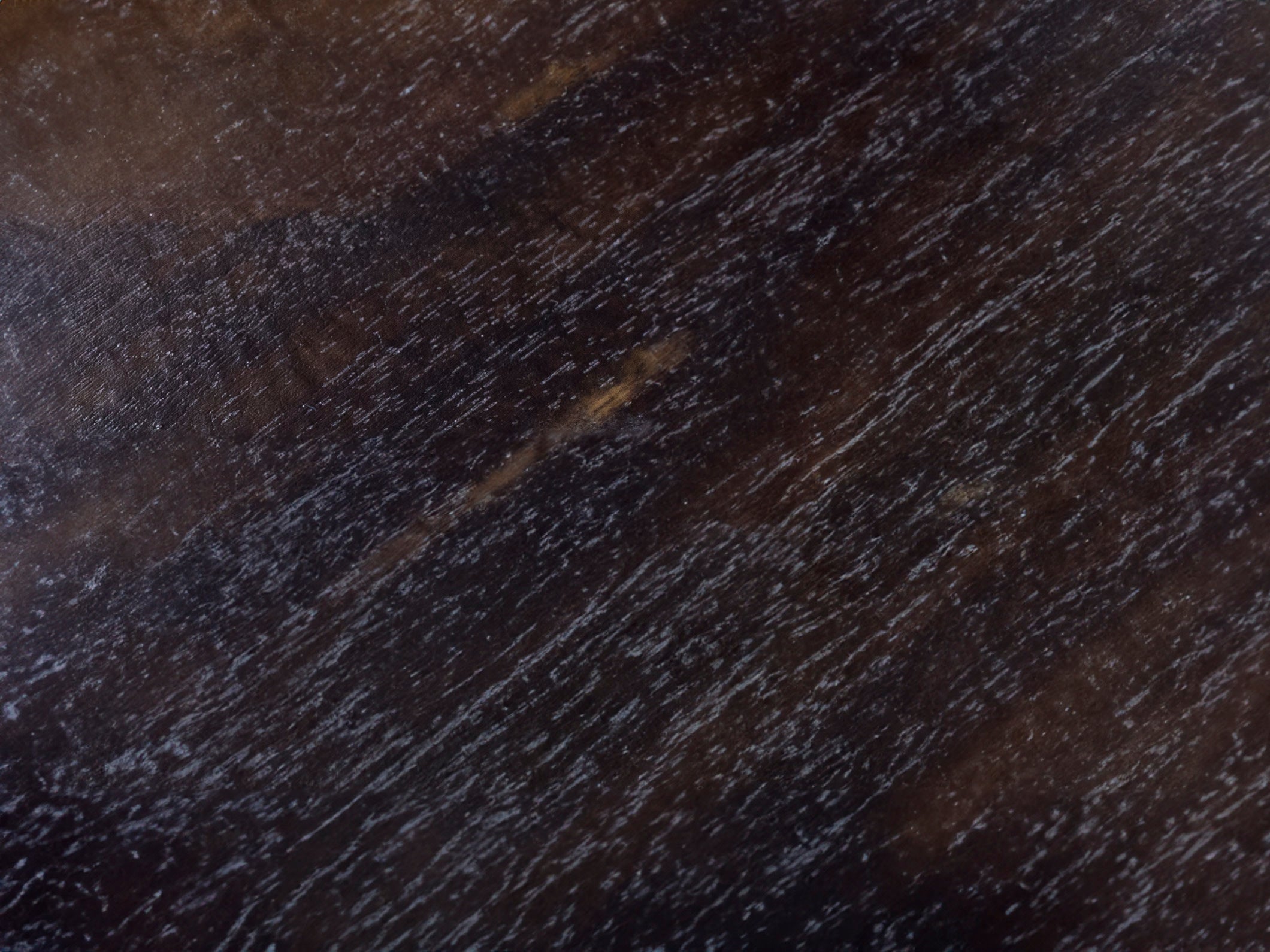 Close-up of dark wood grain texture with brown and black tones.