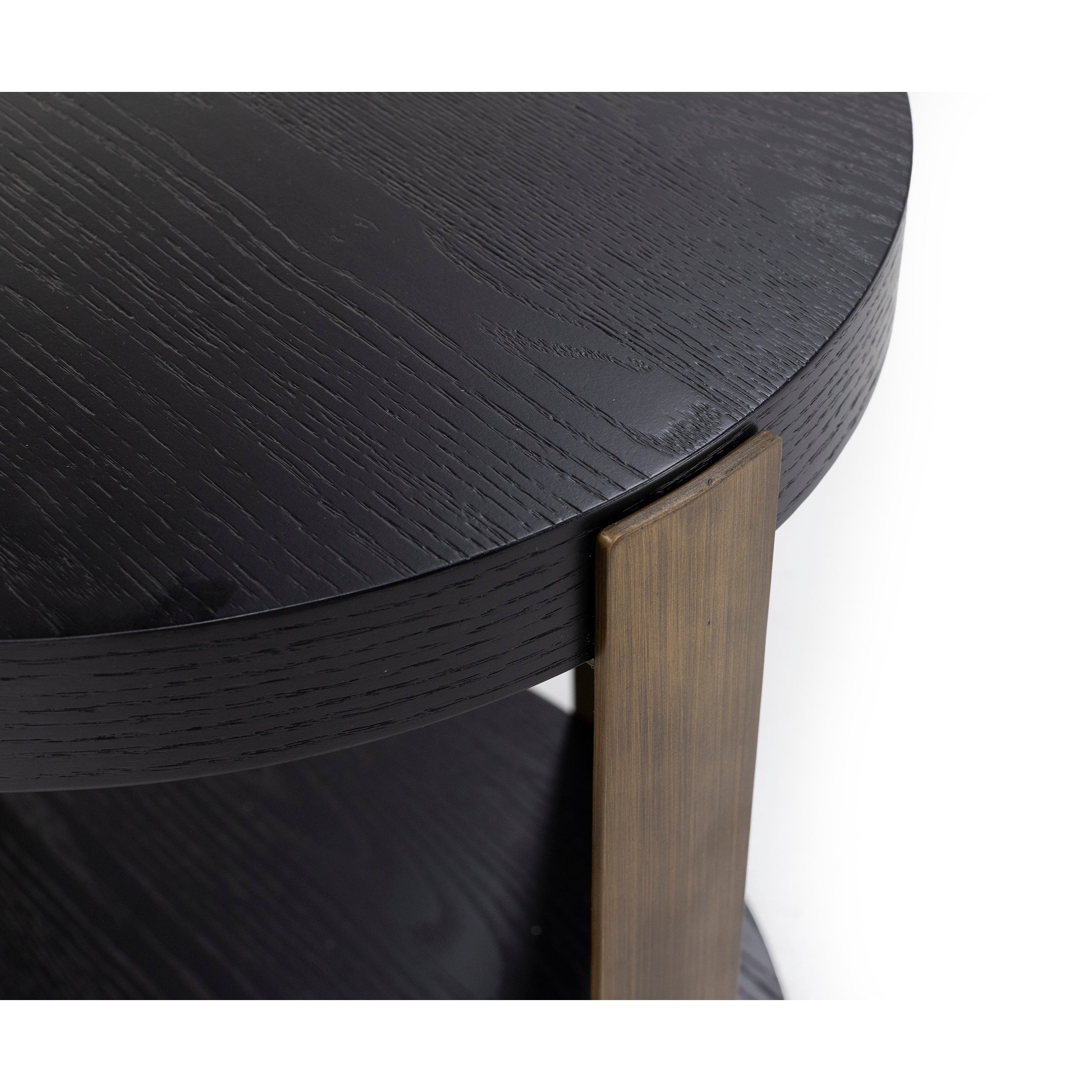 Close-up of a round black wood table with a bronze metal leg.