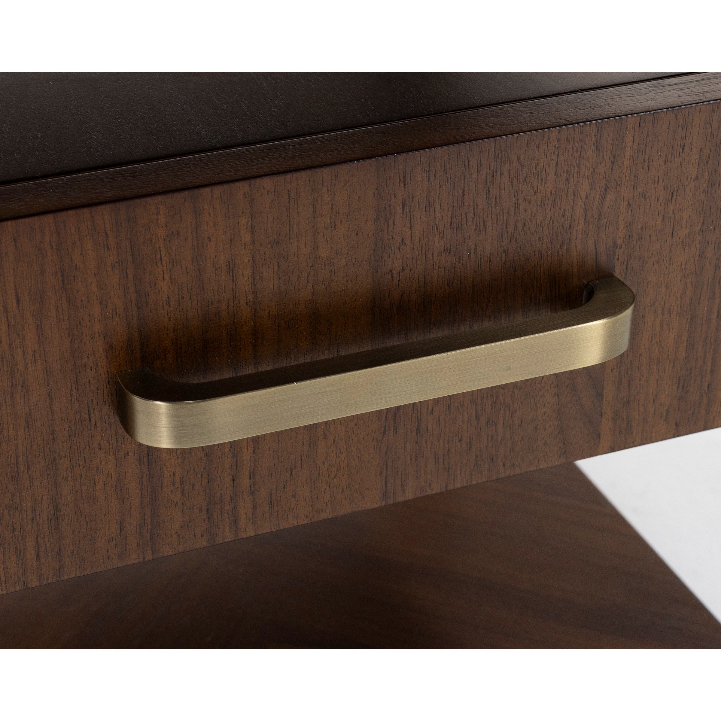 Brushed brass handle on a dark wood drawer