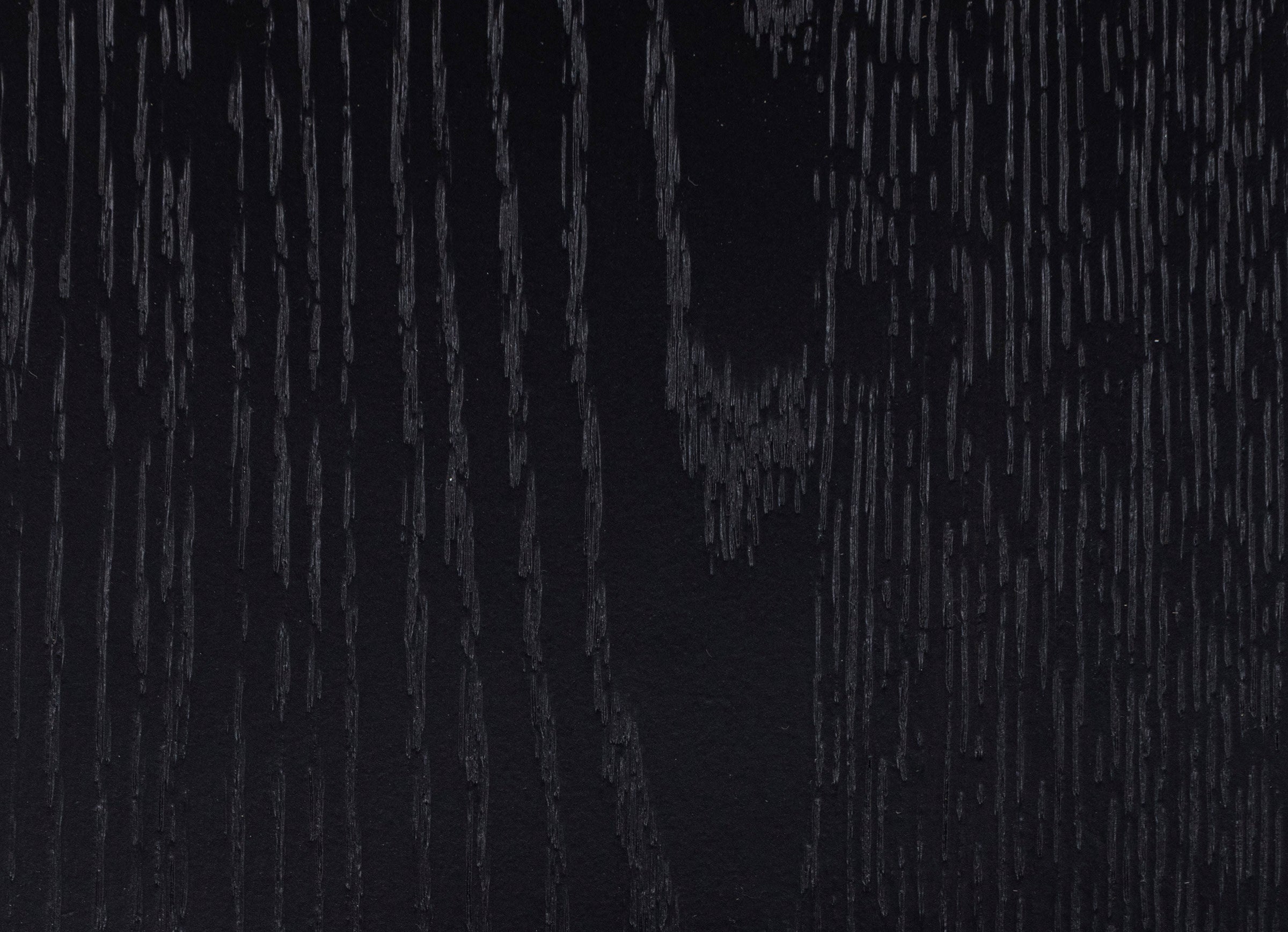 Black wood surface with visible grain texture.