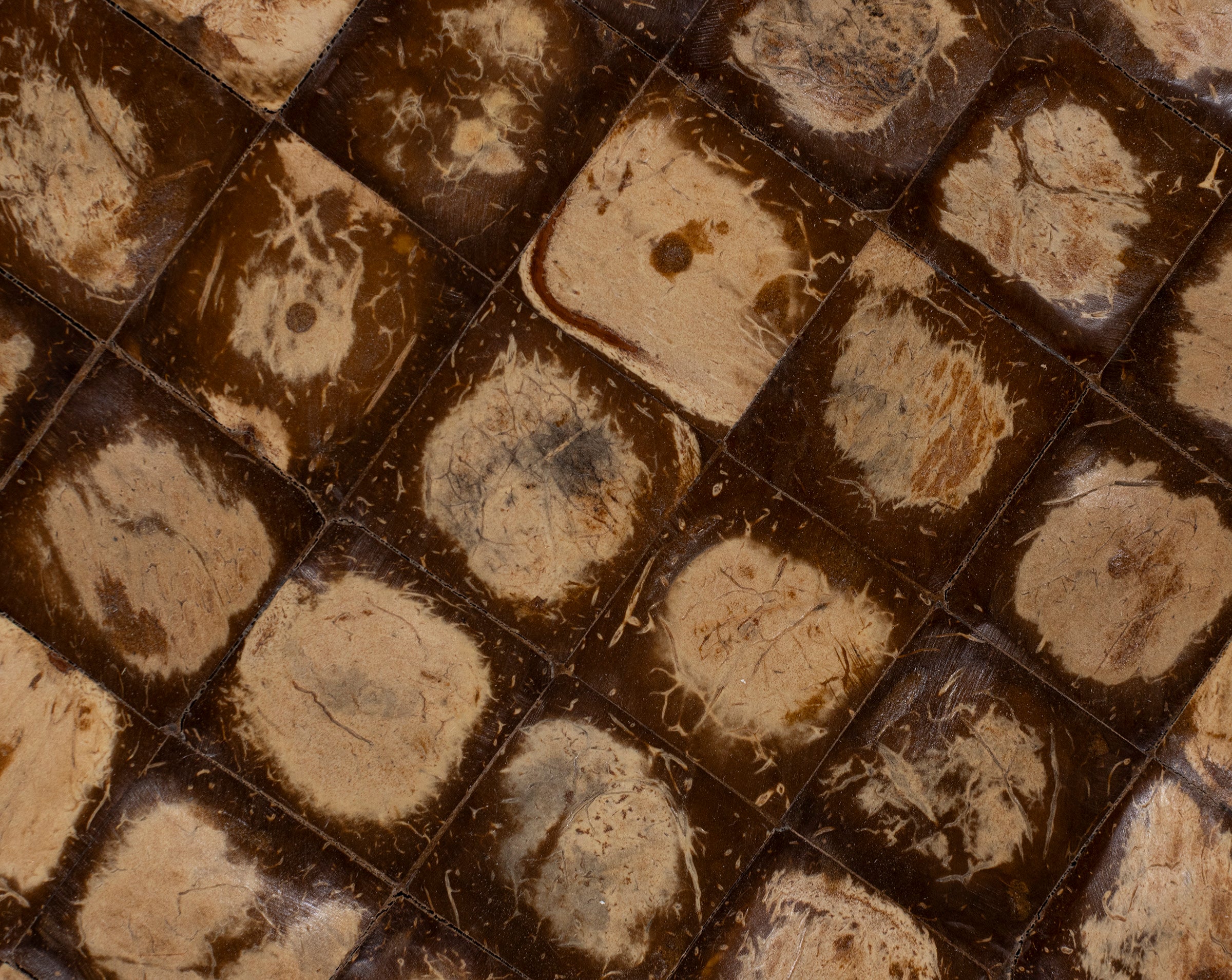 Close-up of a textured brown and beige woven surface with square and circular patterns.