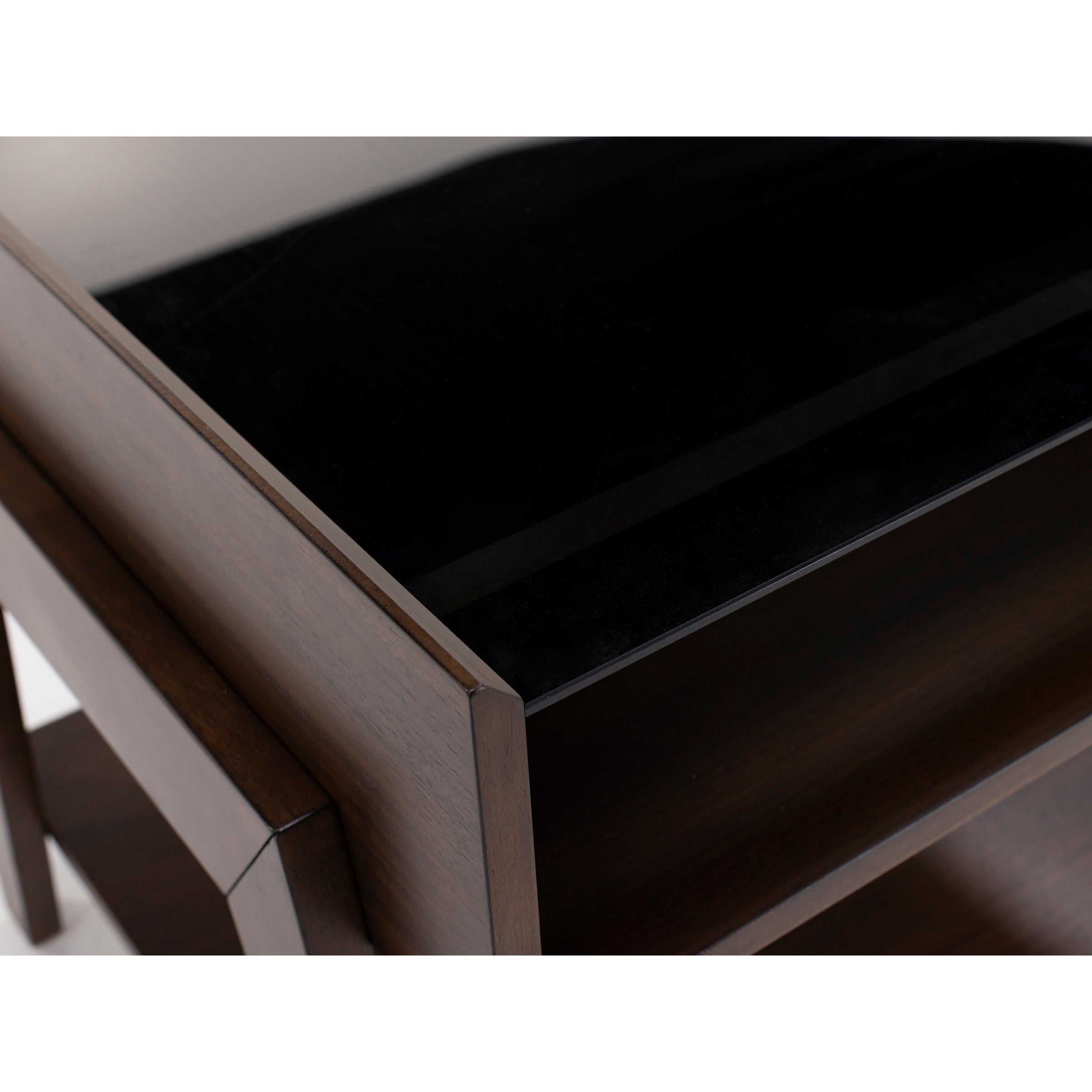 Close-up of a wooden table or desk with a glossy black top.