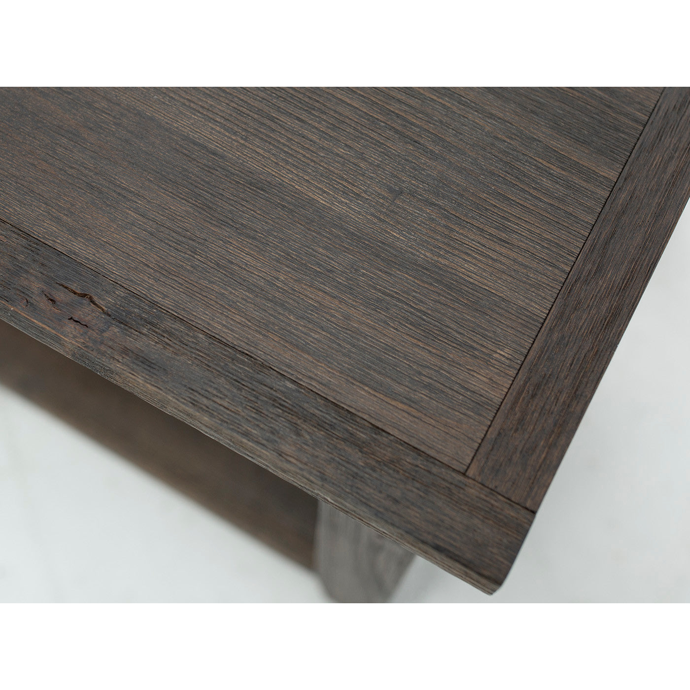 Close-up of dark wood table corner showing natural wood grain texture.