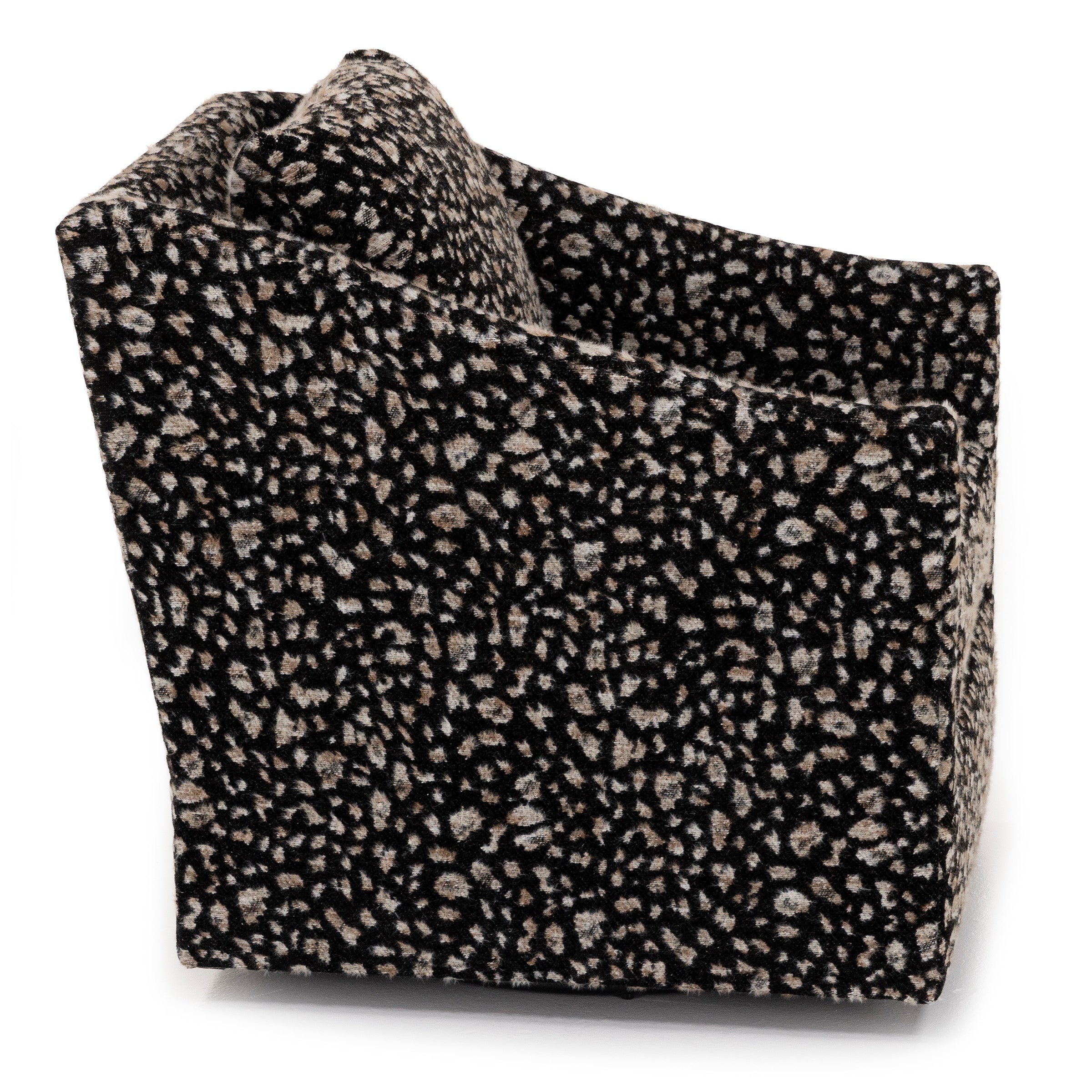 Side view of an armchair with black and beige patterned upholstery.