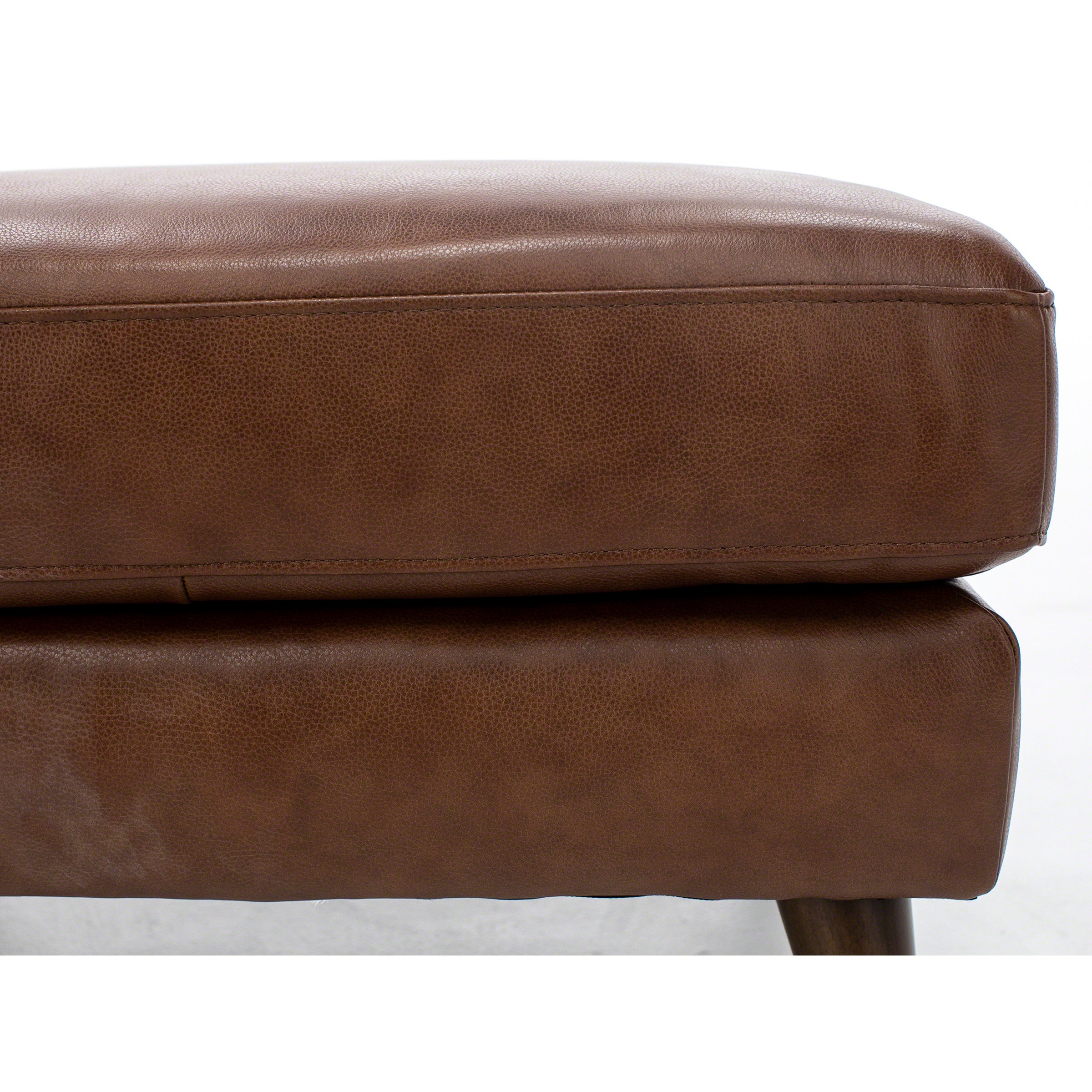 Close-up of a brown leather cushion on a piece of furniture.