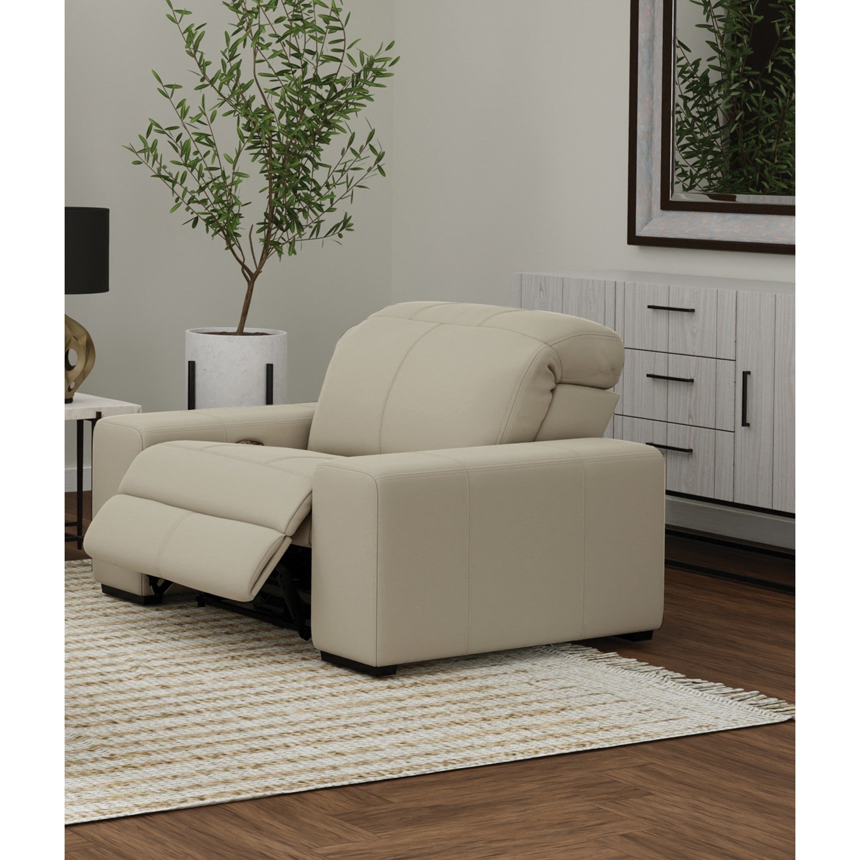 Beige recliner chair in a modern living room with a light rug and decorative plant.
