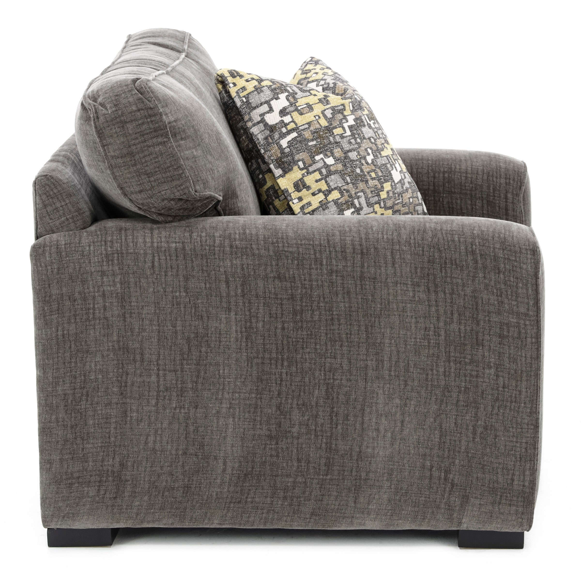 Side view of a modern gray sofa with patterned accent pillows.