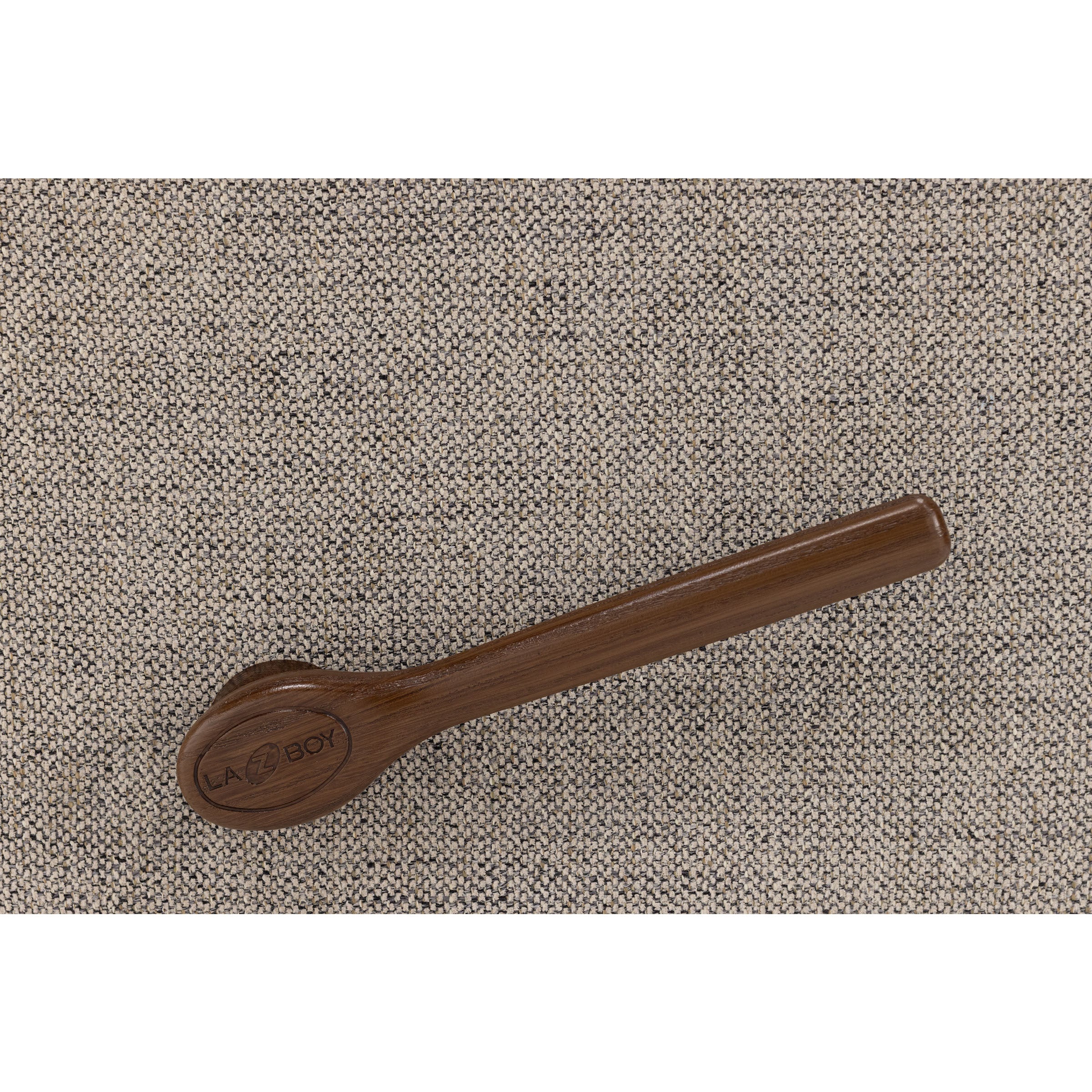 Close-up of a dark wooden recliner handle on textured beige fabric.