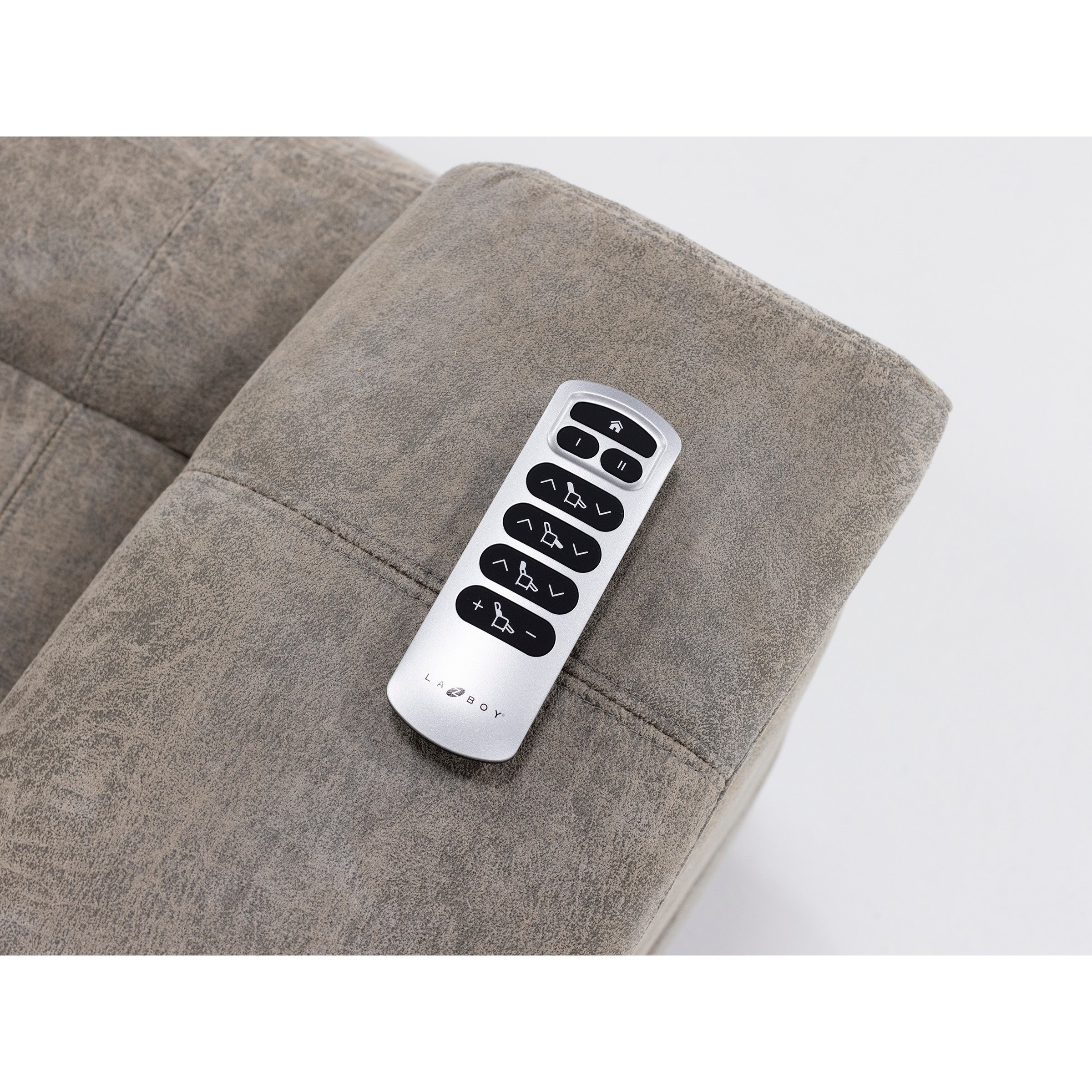 Remote control on sofa armrest for adjusting recliner positions.