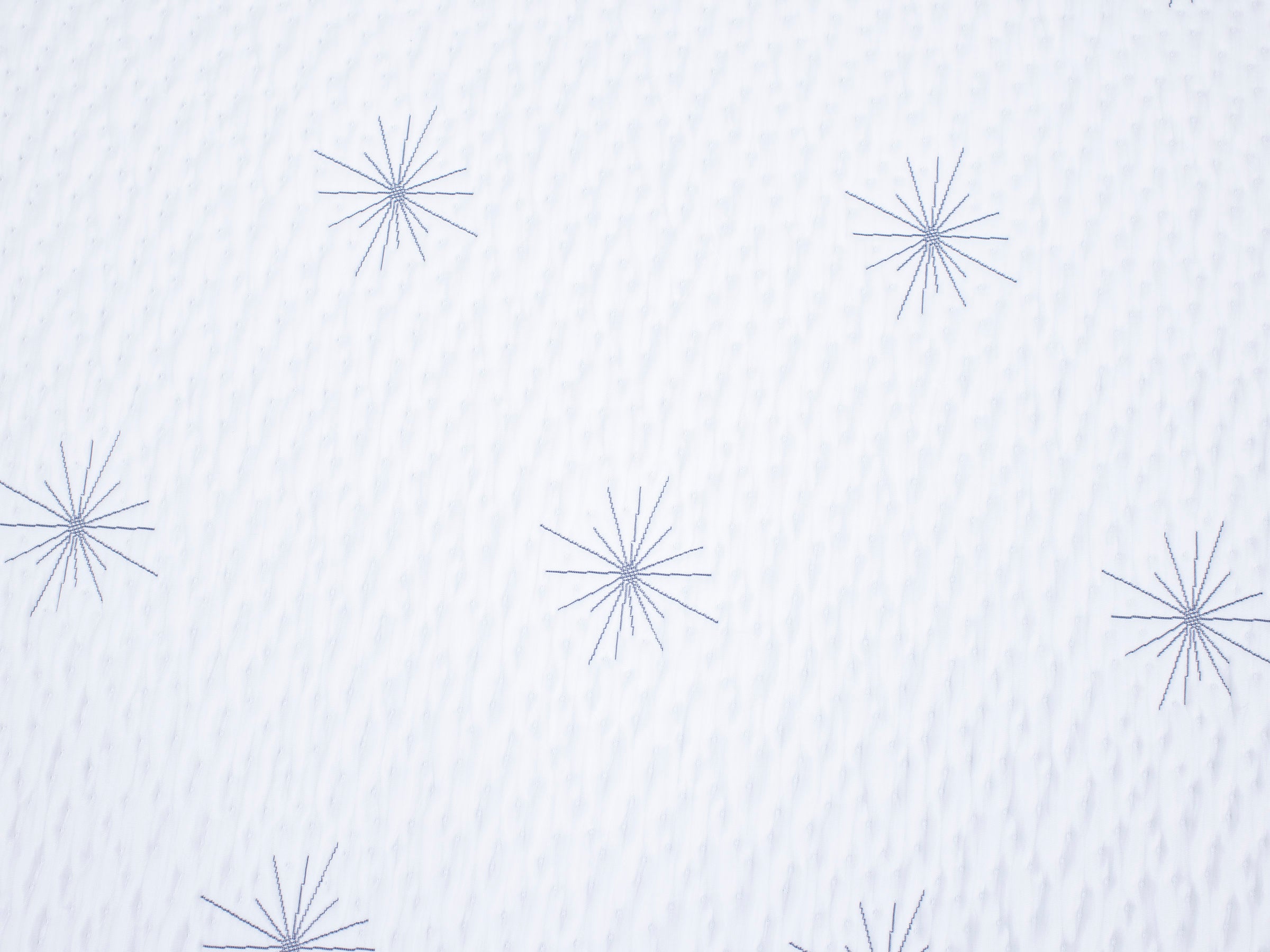 White fabric with navy starburst pattern.