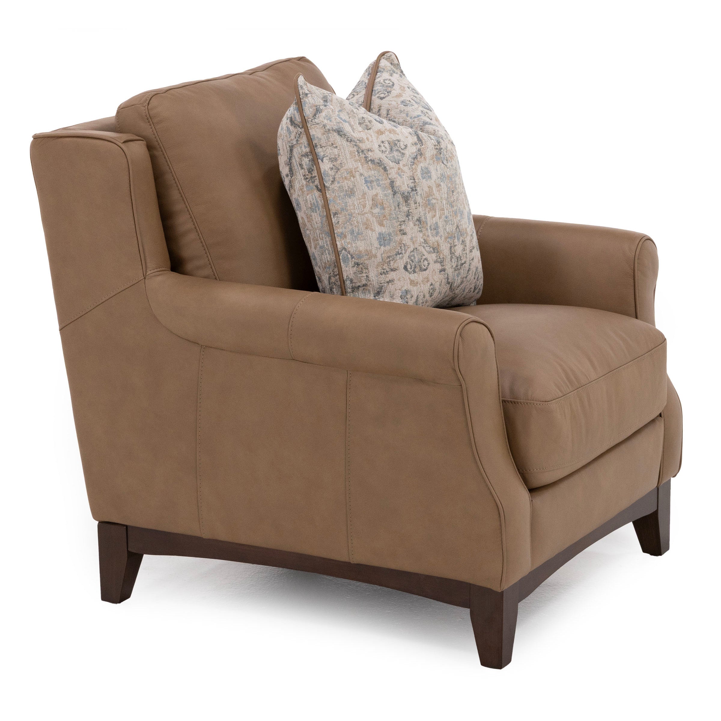 Brown leather armchair with patterned throw pillow, shown at an angle against a white background.