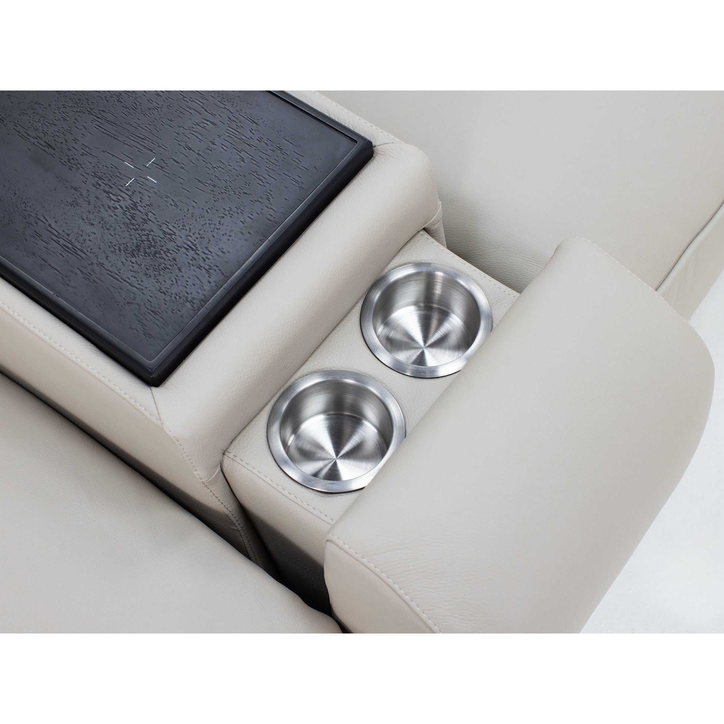 Closeup of a light beige sofa armrest with two built-in stainless steel cup holders.
