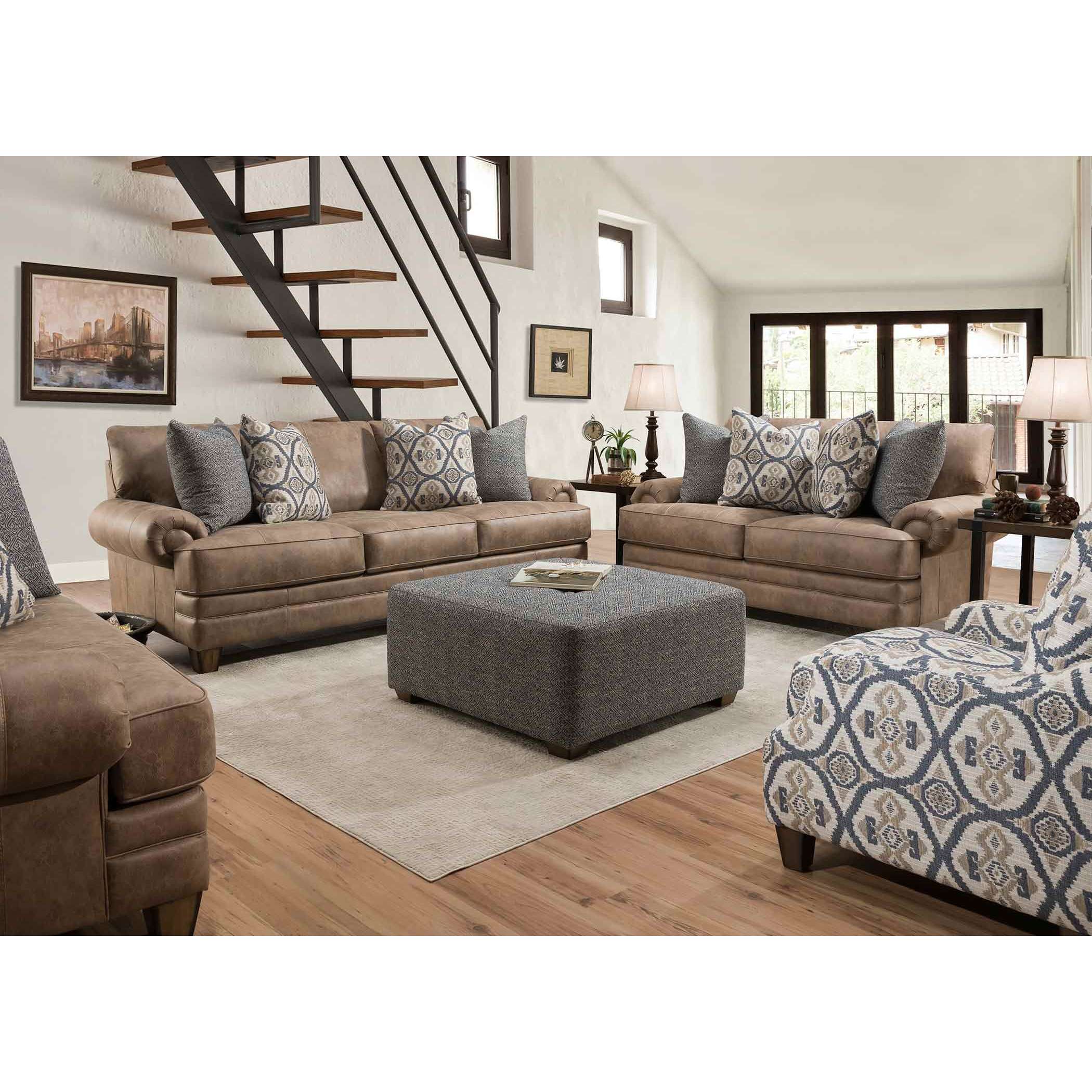 Living room with two tan sofas, patterned pillows, large ottoman, and modern stairs.
