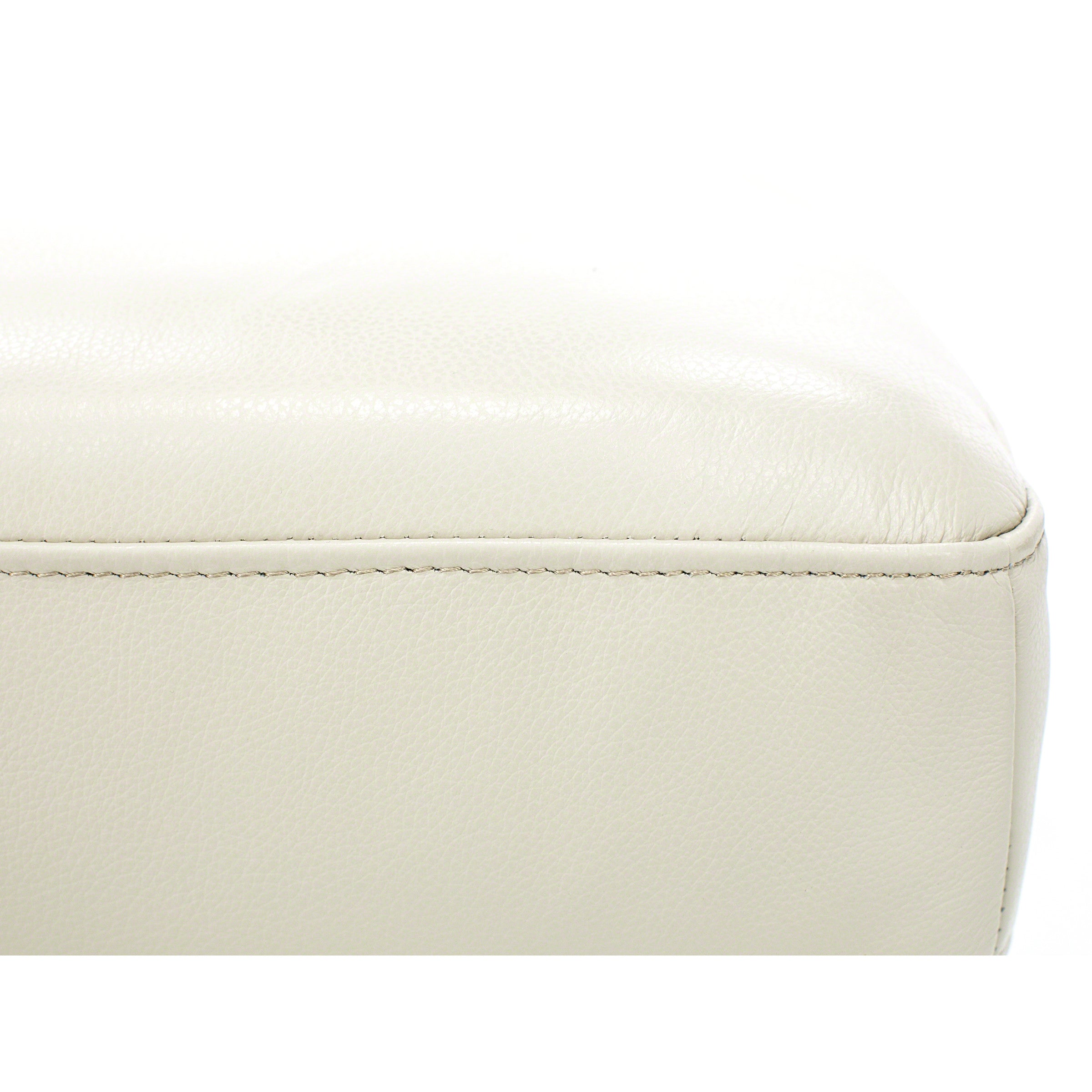 Close-up of beige leather furniture upholstery with visible stitching.