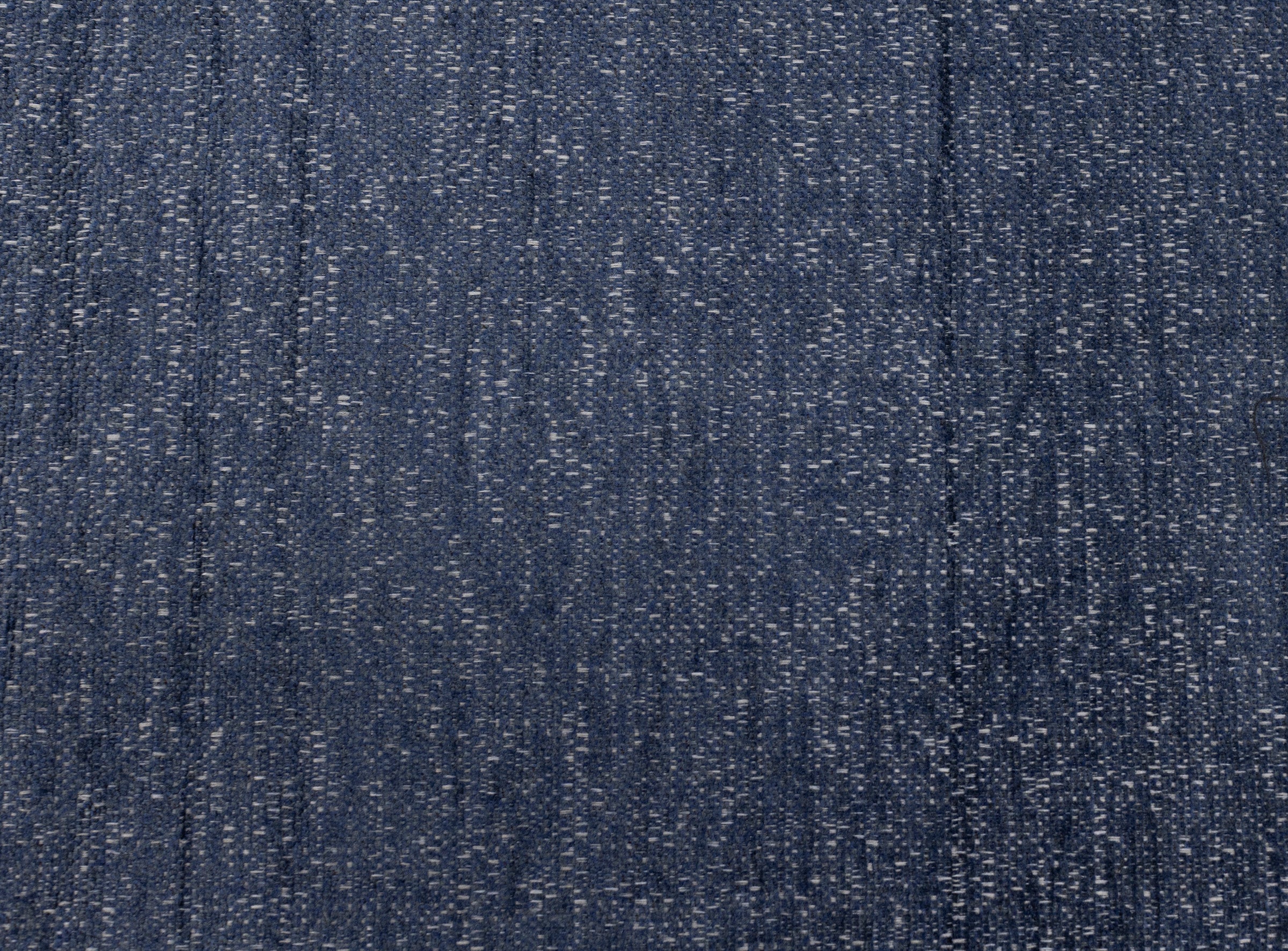 Blue textured fabric pattern with subtle white specks.