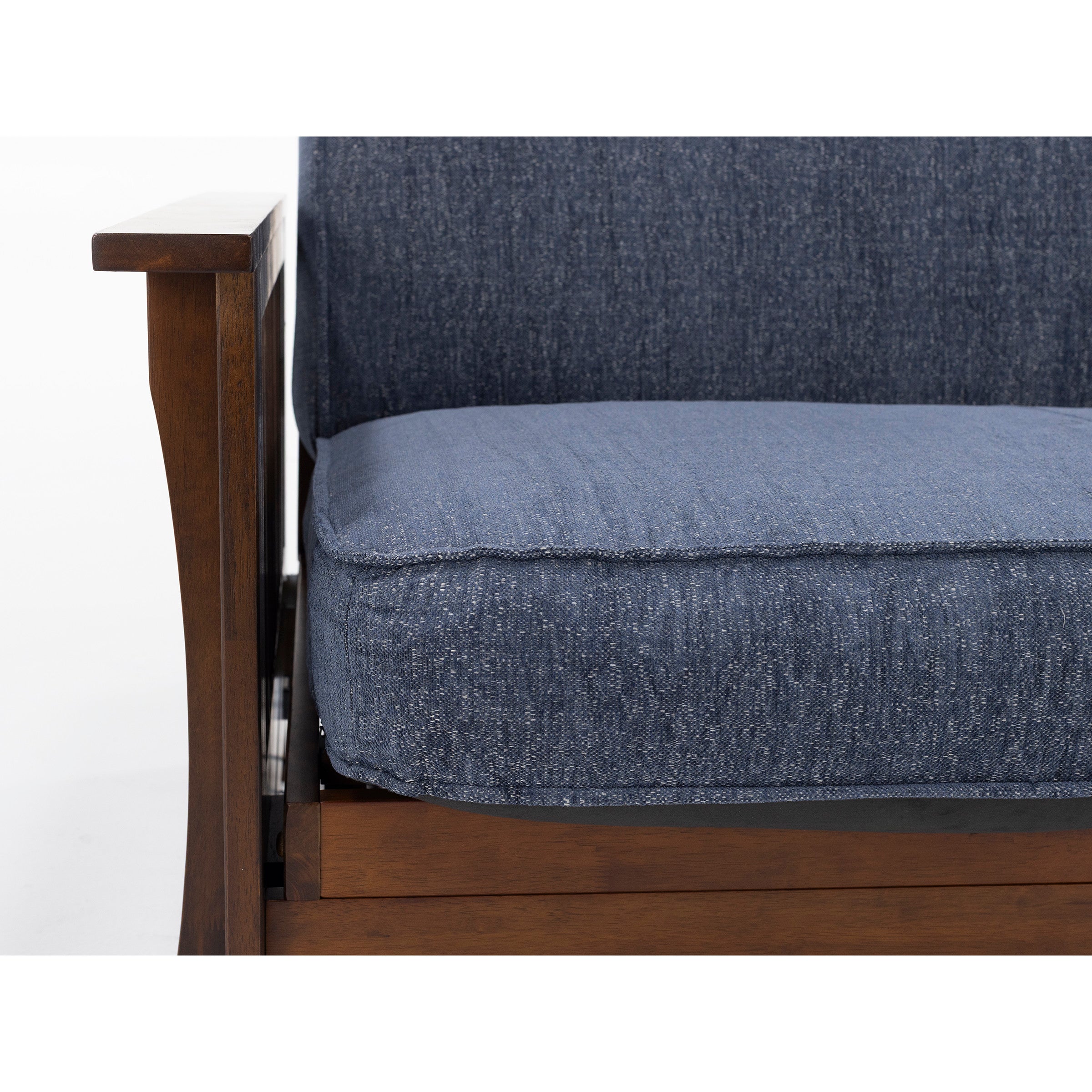 Close-up of a wooden armchair with blue upholstered seat and back cushion.
