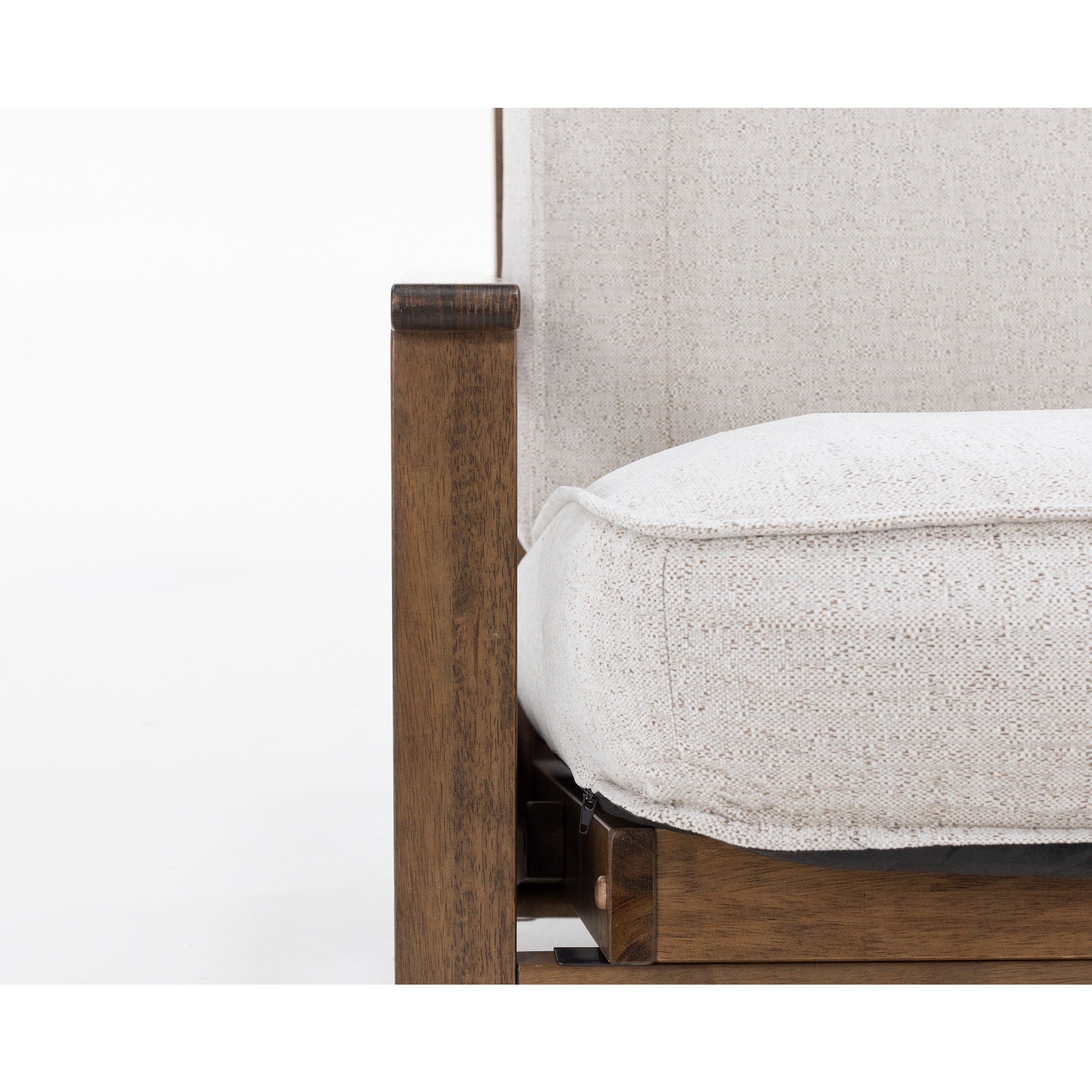 Close-up of a wooden chair armrest with a textured beige cushion and backrest.