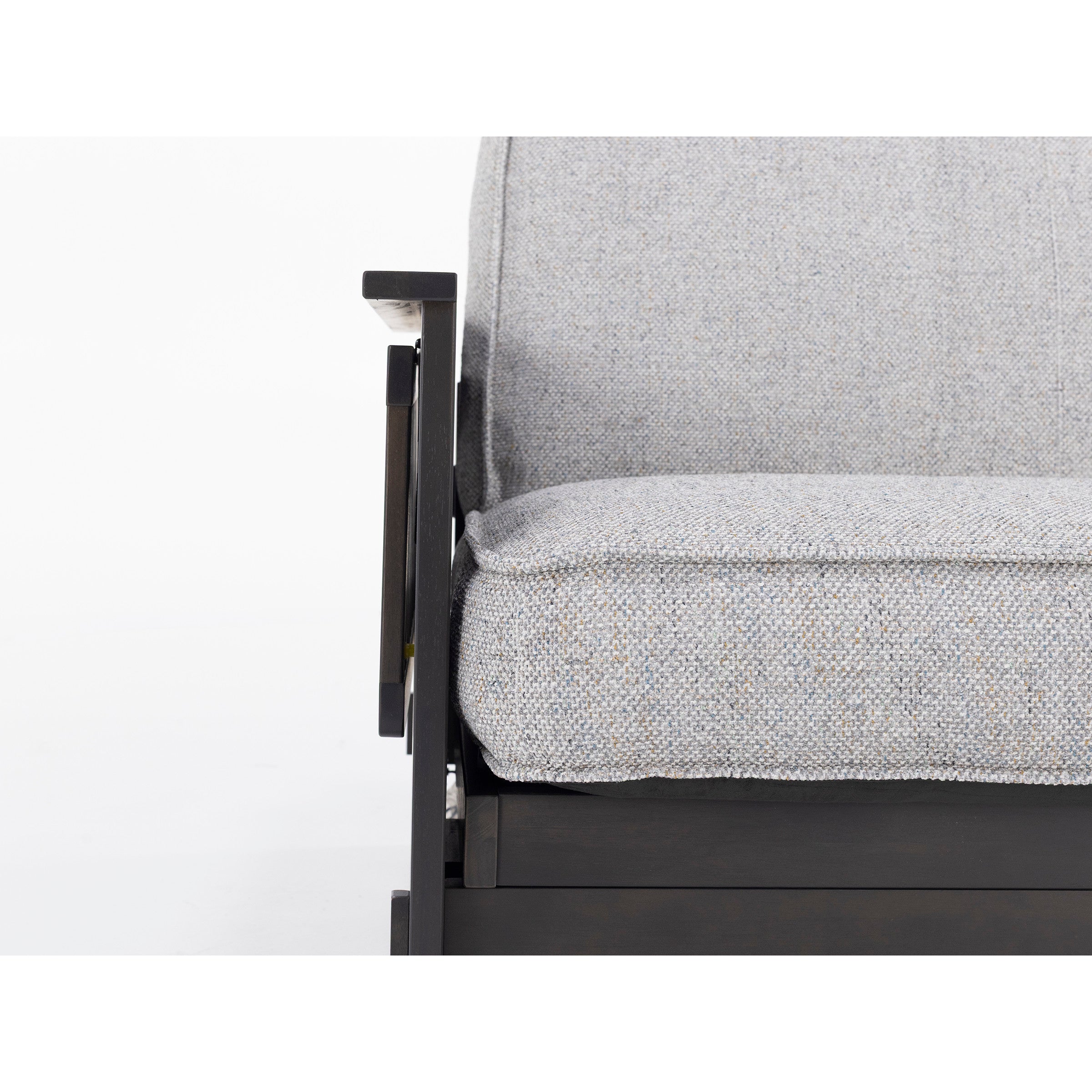 Close-up of a modern sofa arm with light gray cushion and wooden frame.